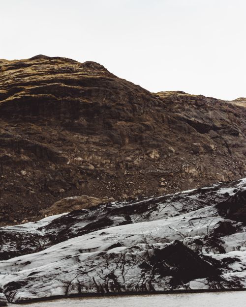 Free Dramatic view of a glacier against rugged mountain landscape, showcasing nature's raw beauty. Stock Photo