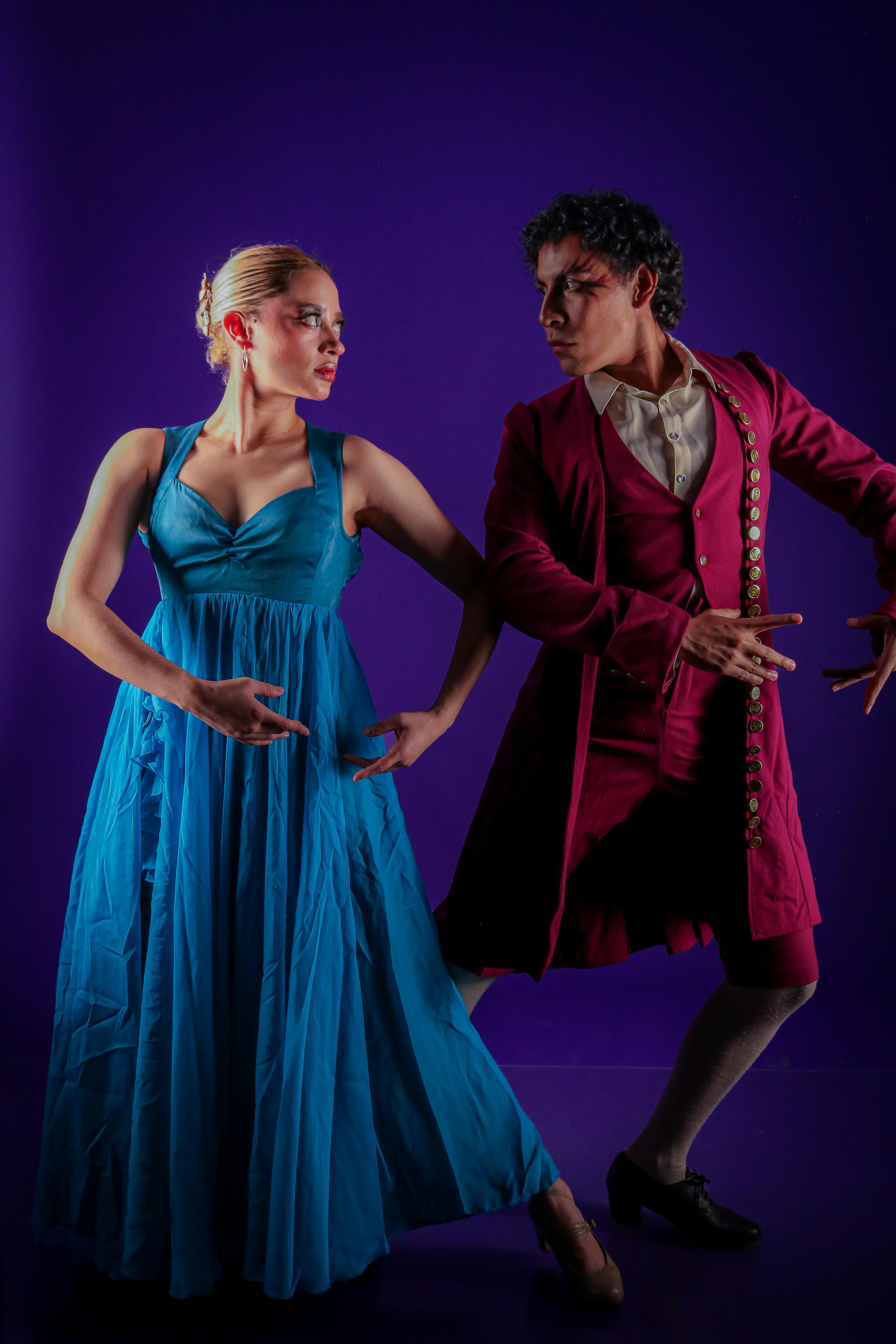 Captivating flamenco dancers performing in colorful attire against a vivid backdrop.