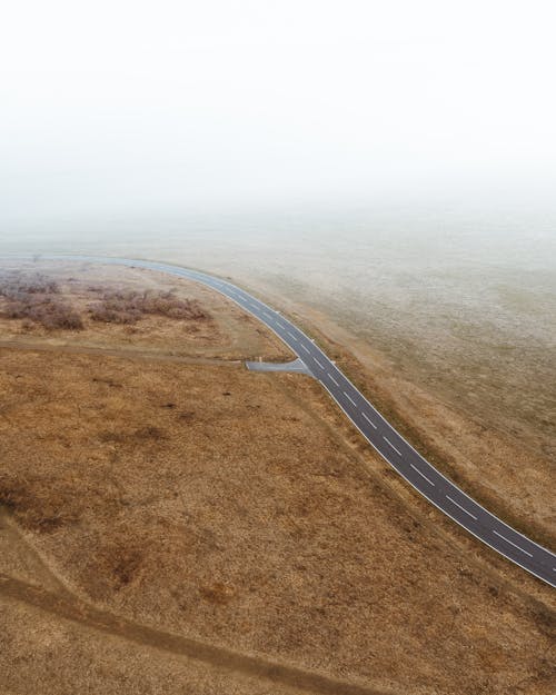 Free Asphalt Road Between Brown Field Stock Photo