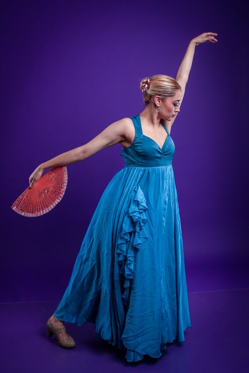 Free Graceful dancer in a vibrant blue dress with fan against a purple backdrop. Stock Photo