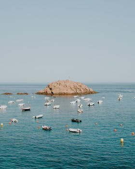 船只停泊在岩石岛屿附近，海面平静