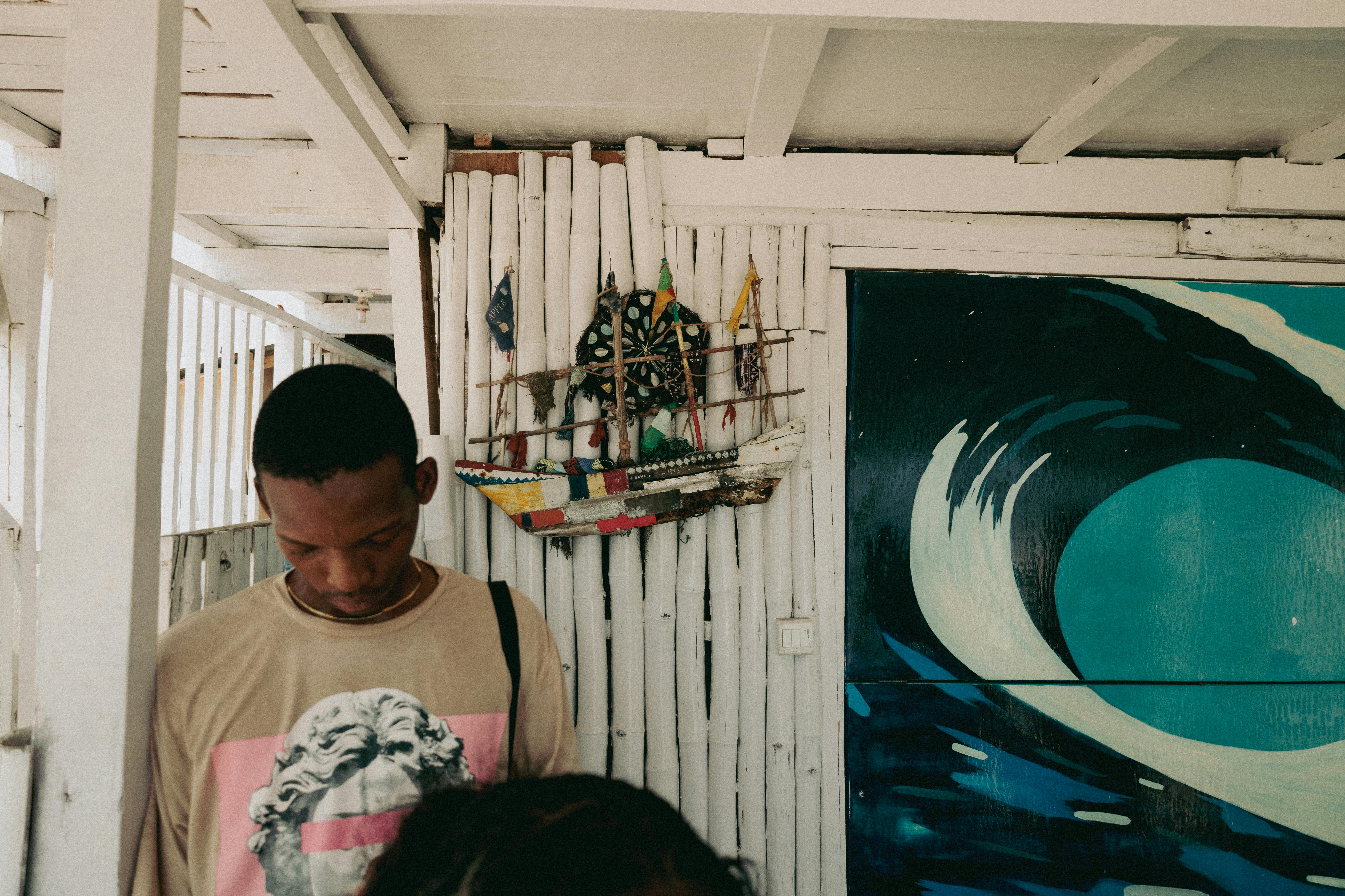 A man stands indoors beside vibrant decor in a Lagos art space.