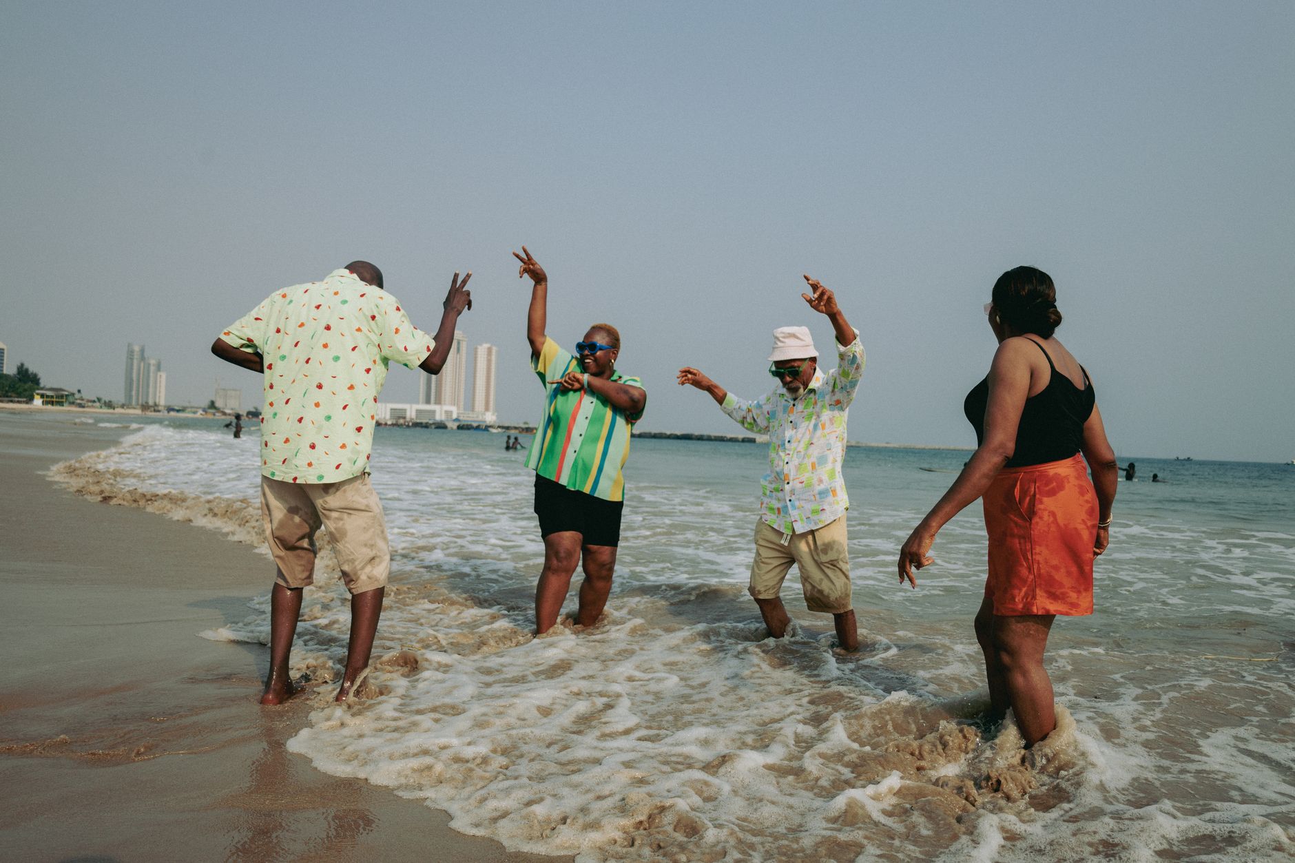 A lively group of adults enjoying a sunny beach day in Lagos, Nigeria.
