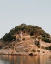 中世纪堡垒矗立在海边，周围环绕着崎岖的景观，景色十分美丽