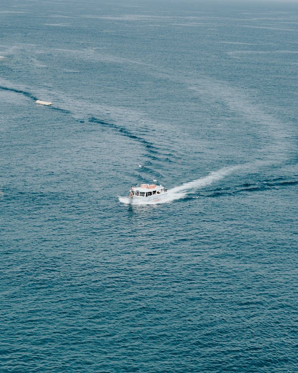 Free White Boat In The Middle Of The Ocean Stock Photo