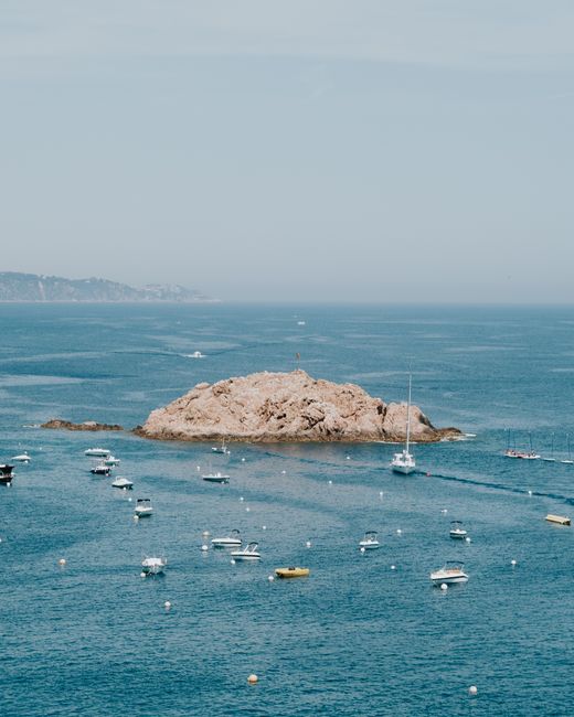 A picturesque view of boats around a rocky island, perfect for travel and leisure enthusiasts