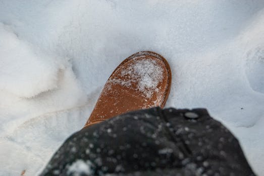 A close-up of a winter boot stepping on fresh snow in Daqing, China.