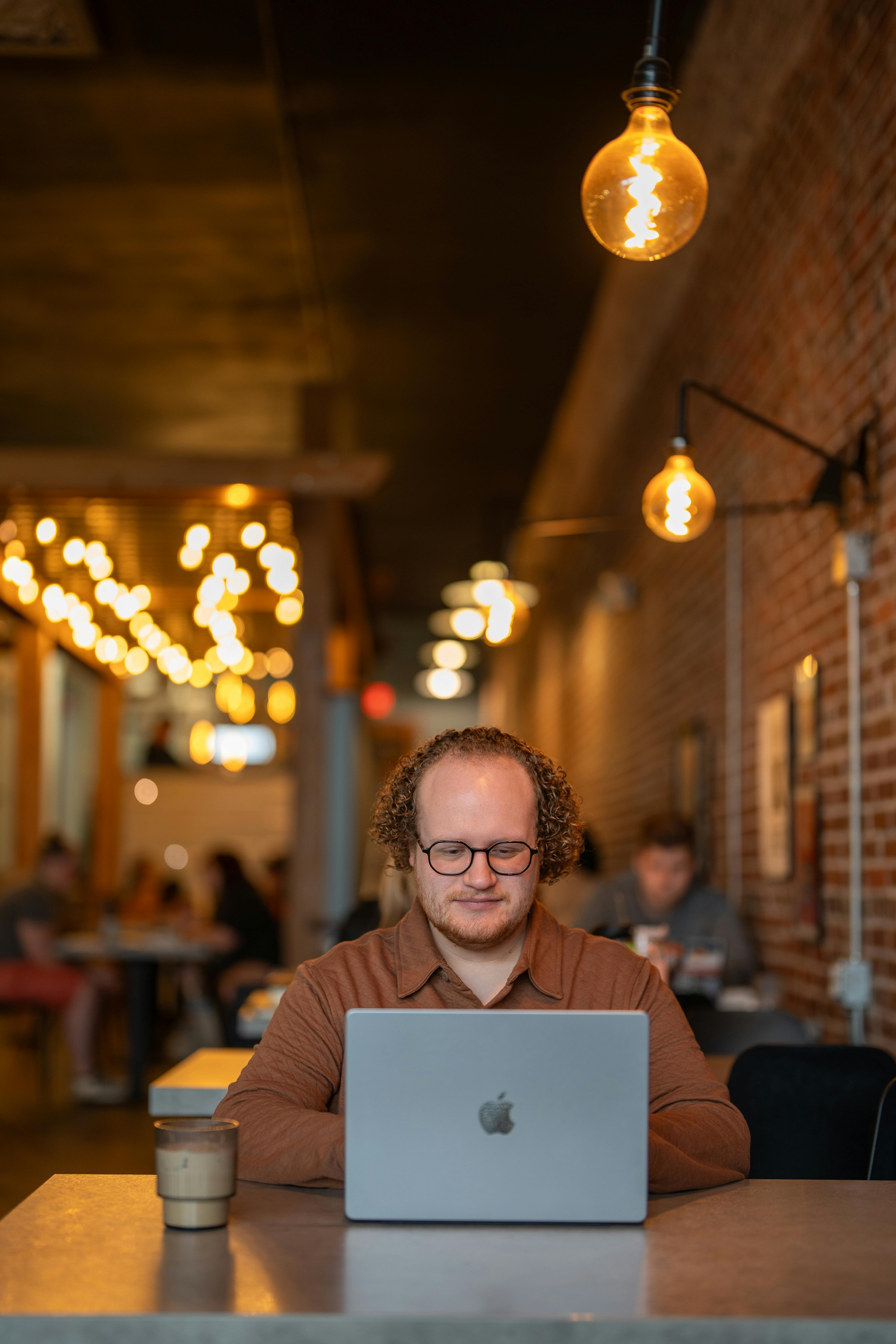 how to make passive income online as a beginner man laptop coffee shop hustletoevolve