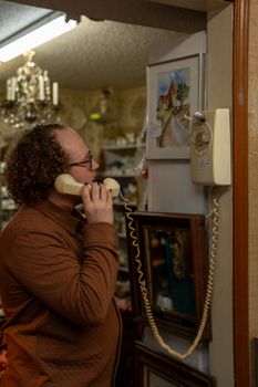 Man using a vintage rotary phone in an antique store in Stillwater, Oklahoma.