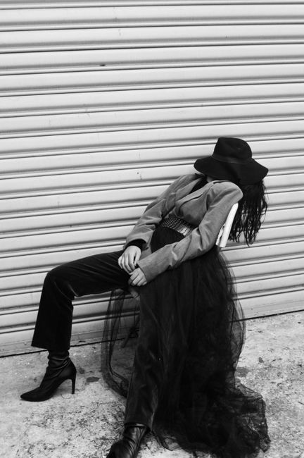 Artistic black and white photo of a stylish model in a dramatic pose.