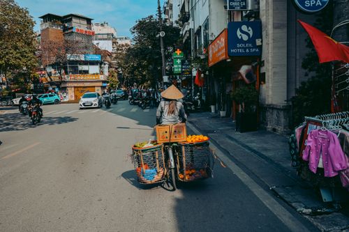 Free A street vendor on a bicycle in a bustling urban market, showcasing local culture. Stock Photo