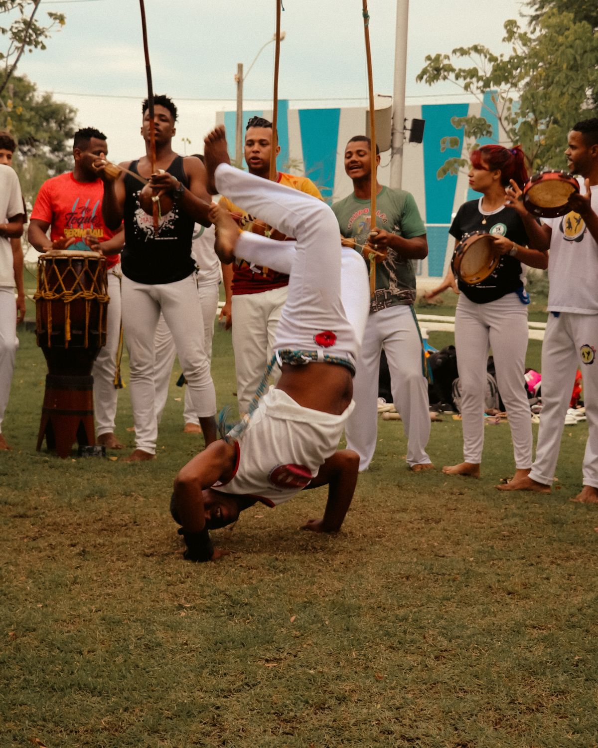 Una roda al aire libre: un capoeirista hace un floreio mientras el grupo toca y canta