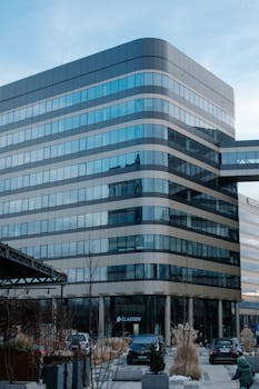 Contemporary glass office building with a reflective facade in Kraków, Poland.