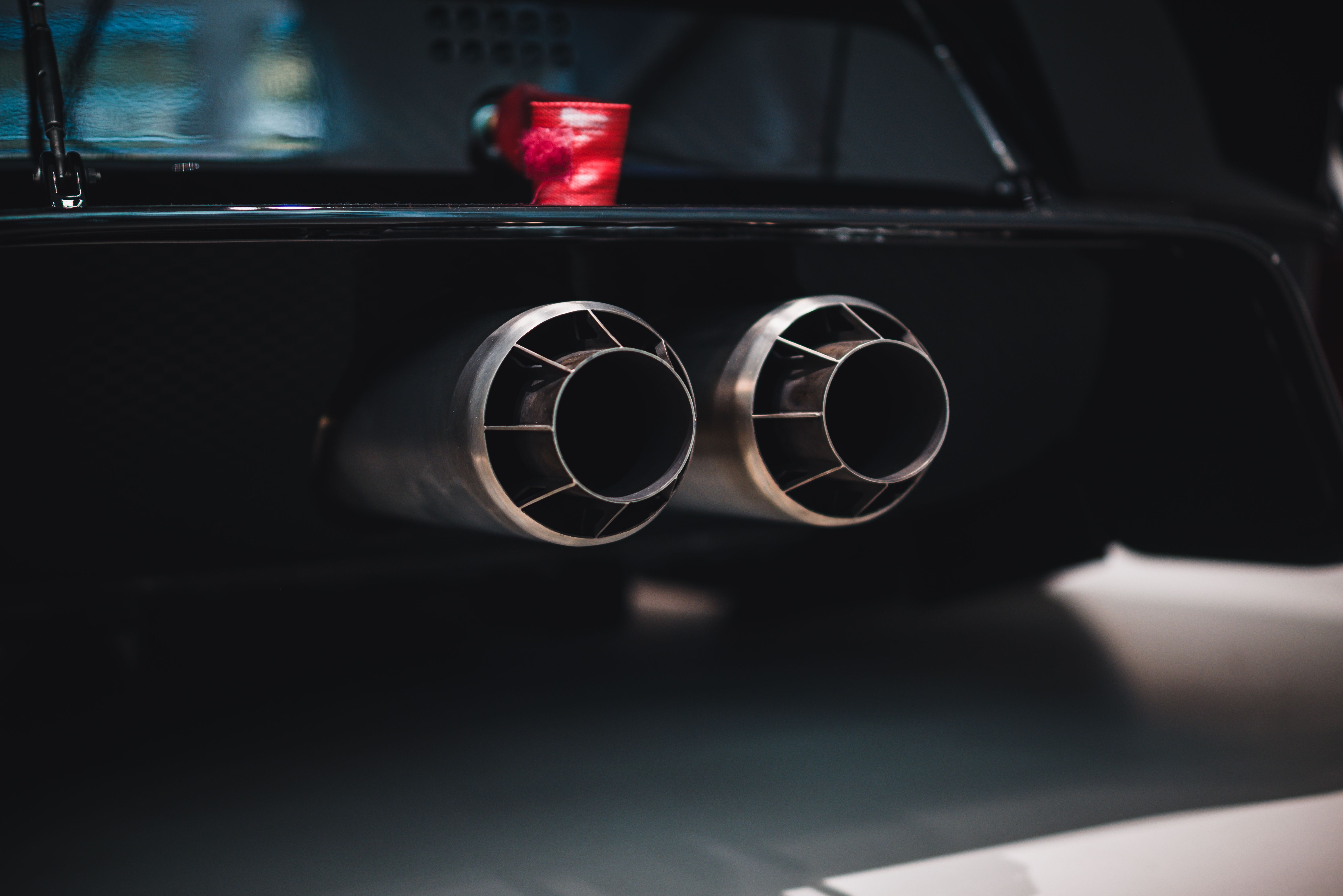 Close-up shot of dual exhaust pipes on a sleek car, with a focus on detail and design.