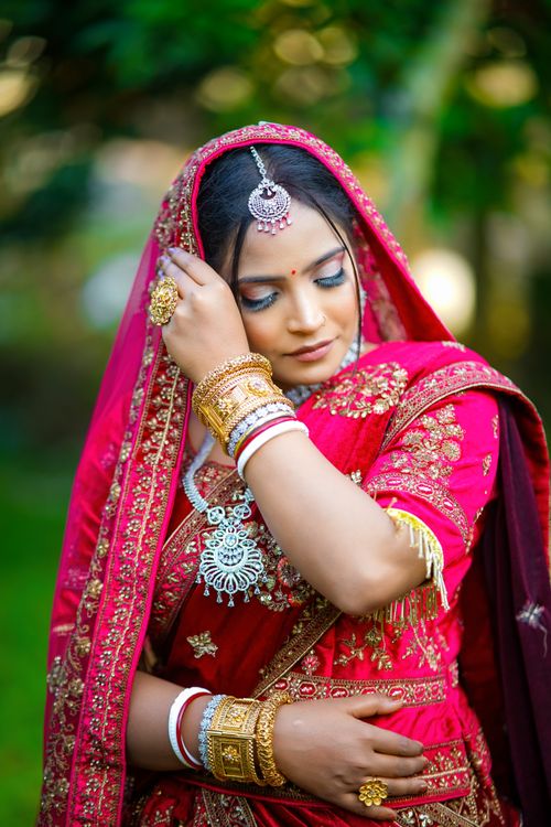 Free Beautiful South Asian bride in vibrant red traditional attire with intricate jewelry. Stock Photo