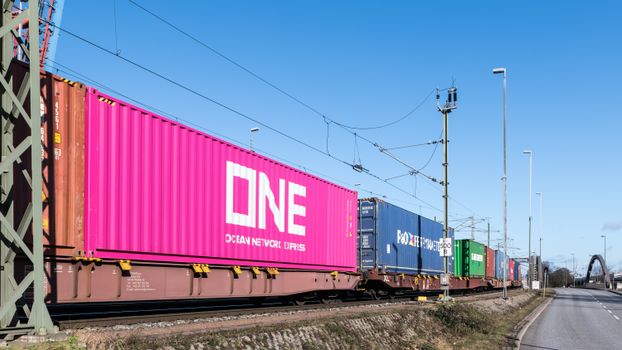 Colorful freight train containers passing through a rail line in Hamburg, Germany.