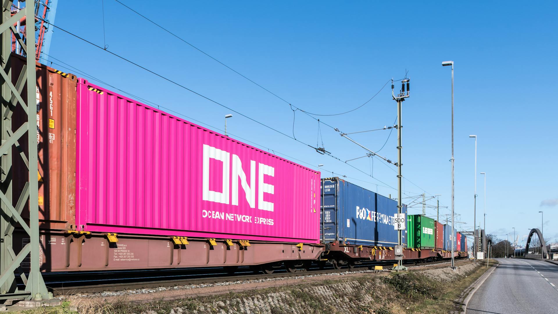 Colorful freight train containers passing through a rail line in Hamburg, Germany.