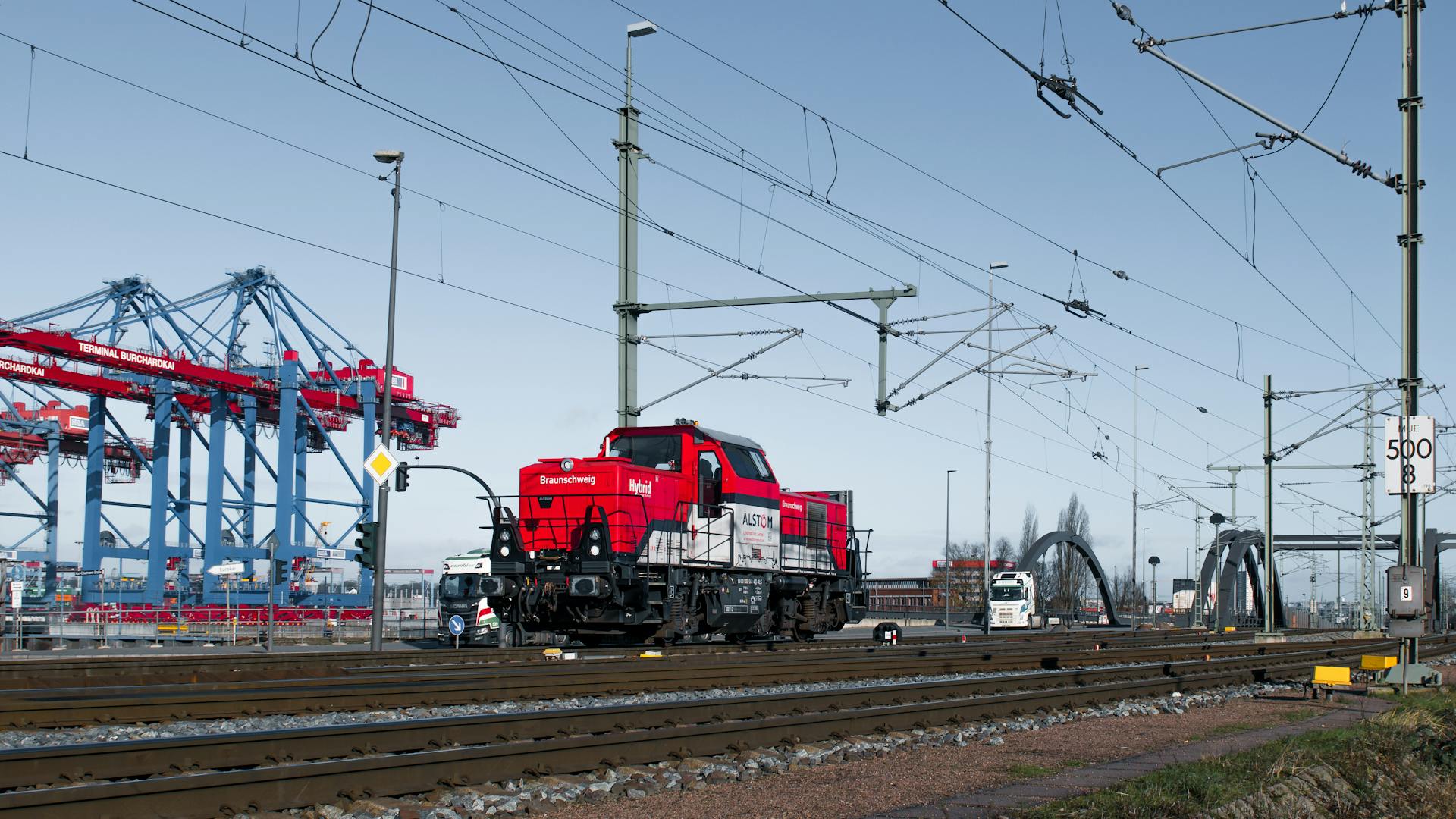 Freight train and cranes at Hamburg Port's rail terminal in Germany.