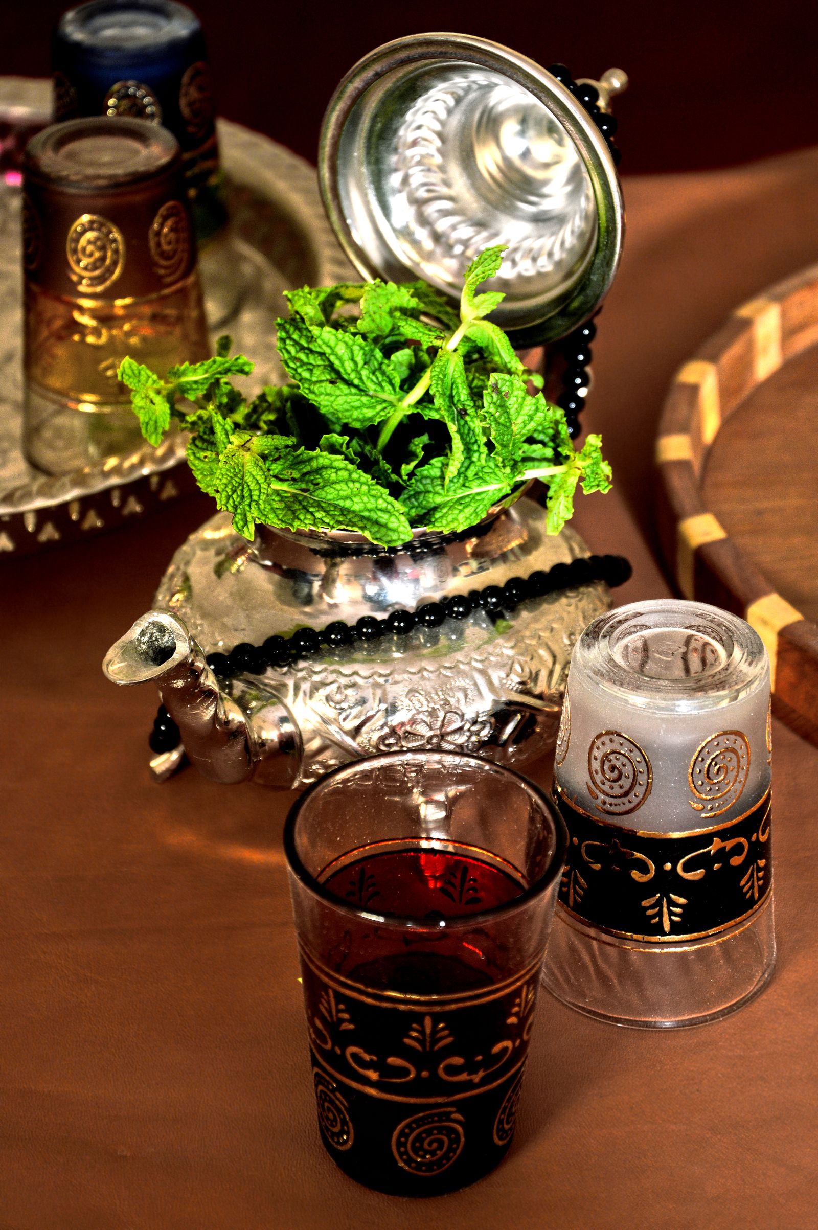 Elegant arrangement of traditional Moroccan mint tea with ornate glasses and silver teapot