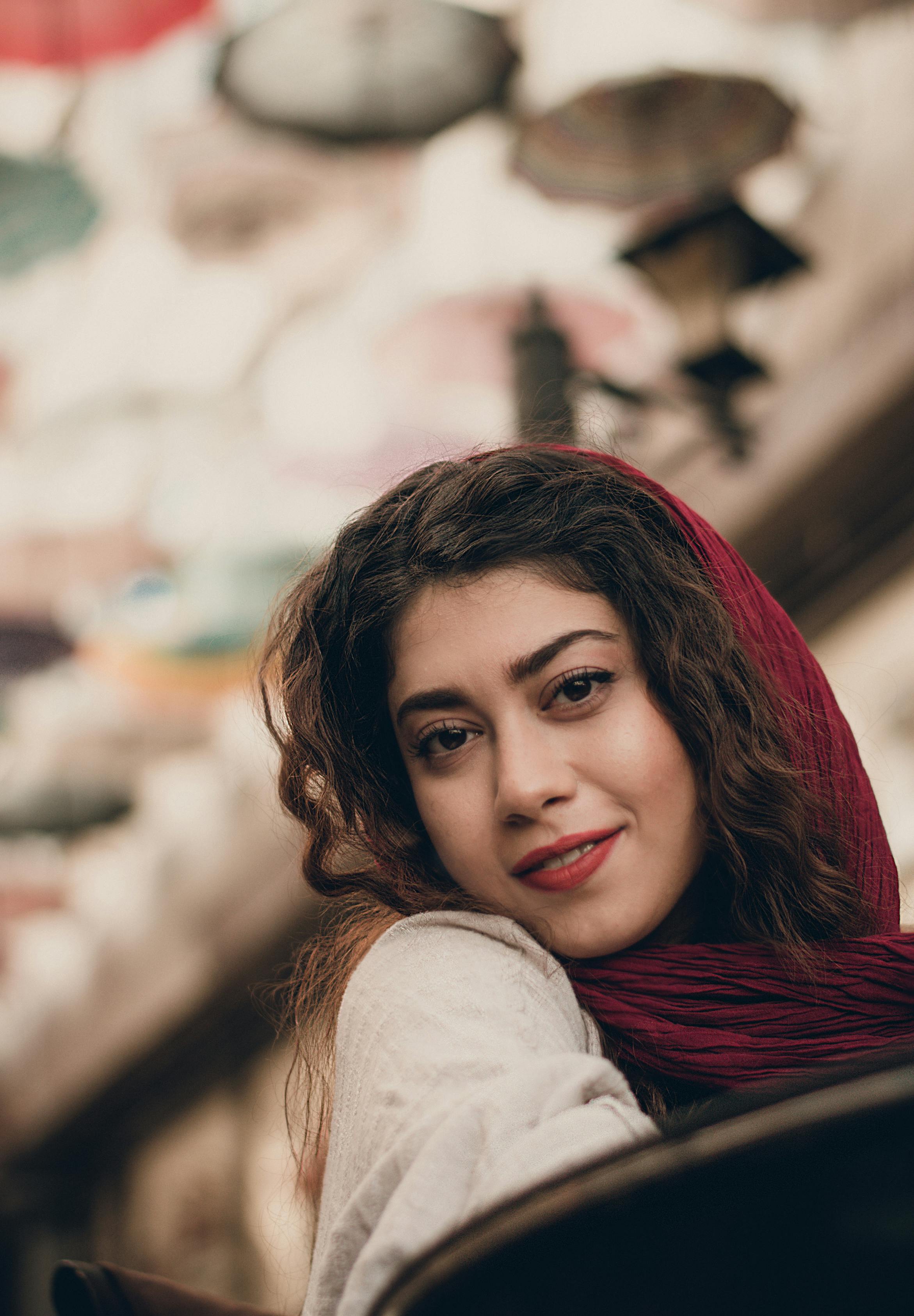 一位戴着头巾的女人在户外奇思妙想的环境中微笑的肖像