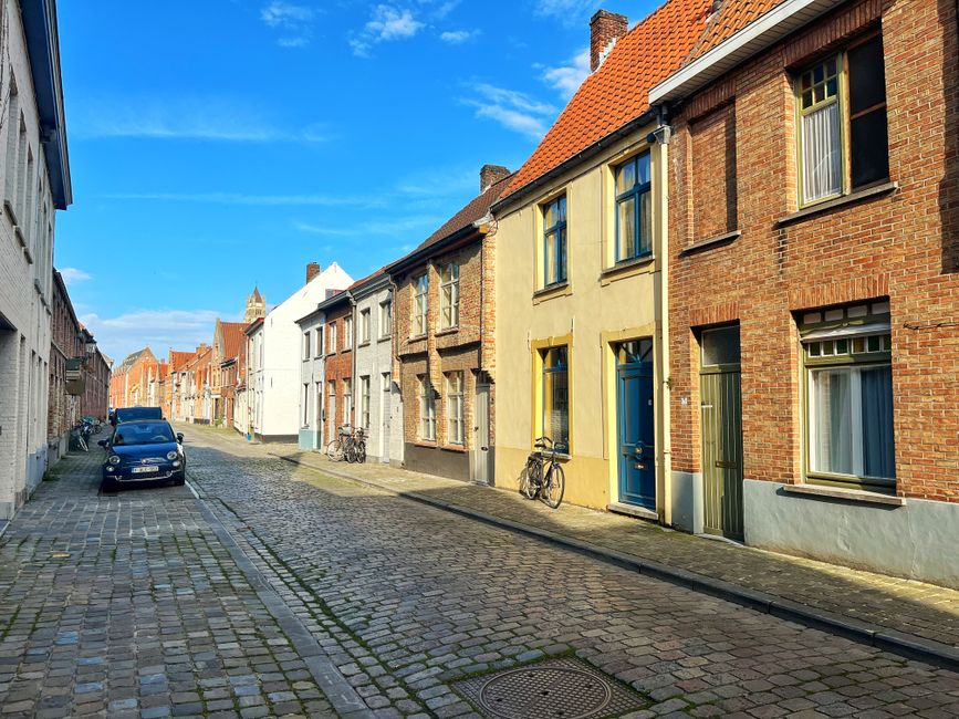 A cobblestone street lined with bicycles in the historic centre of Bruges, Belgium.