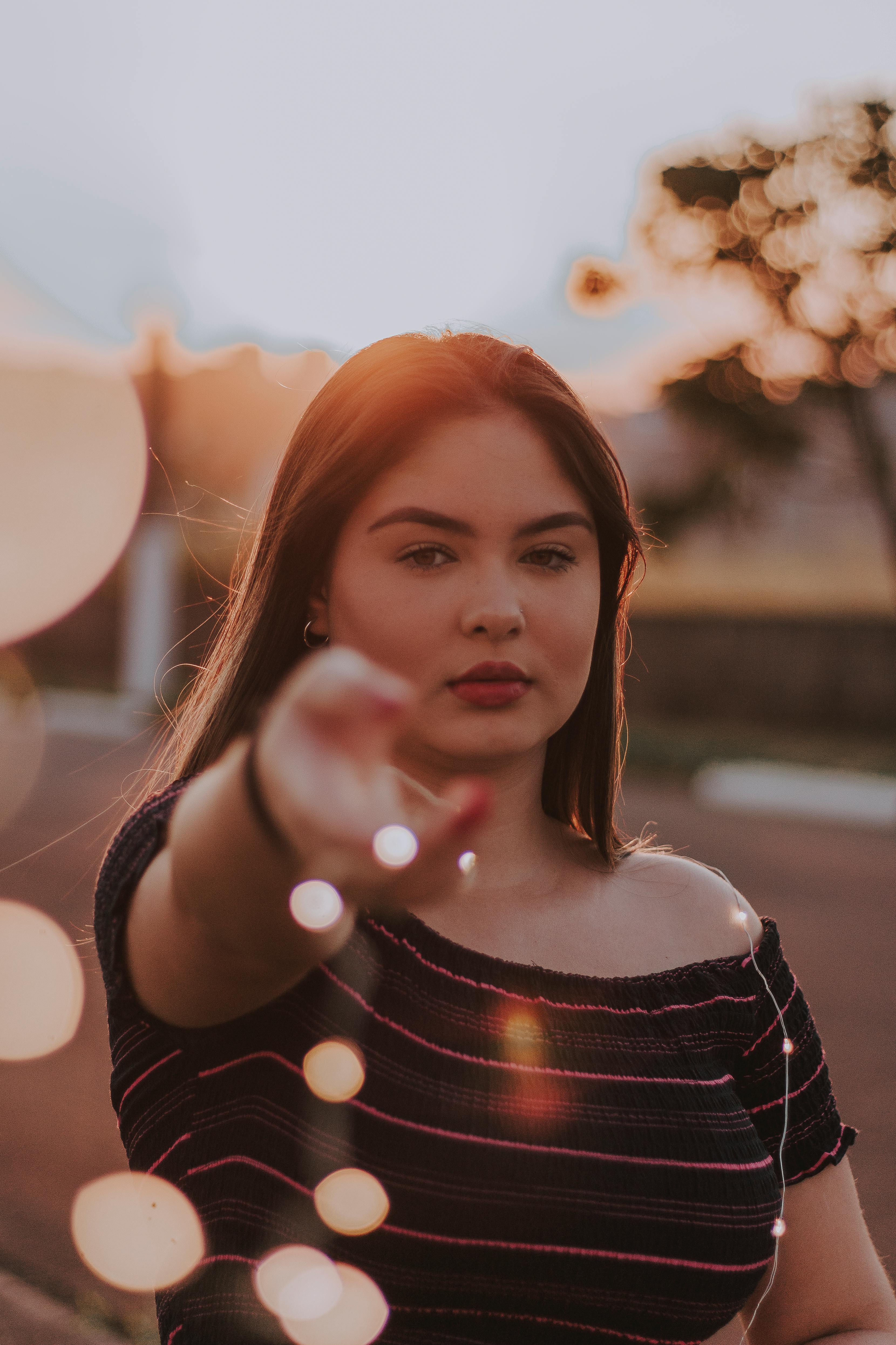 一位年轻女子在户外，光线柔和梦幻，呈现散景效果