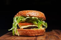 A delicious gourmet cheeseburger with fresh lettuce, tomato, and cheese on a sesame bun.