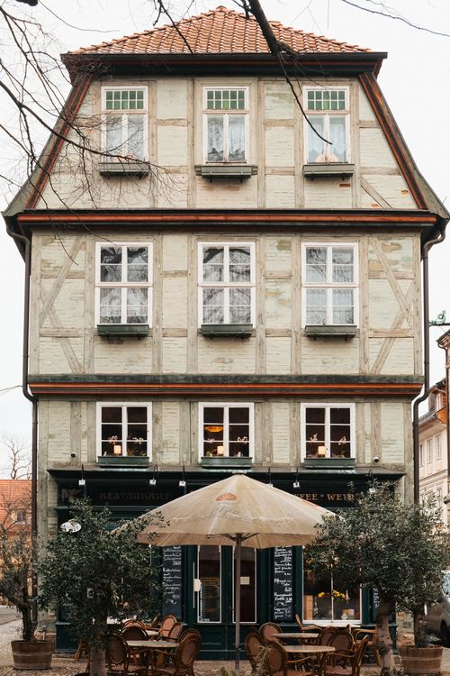 Free A picturesque half-timbered building with outdoor cafe seating in Quedlinburg's old town. Stock Photo