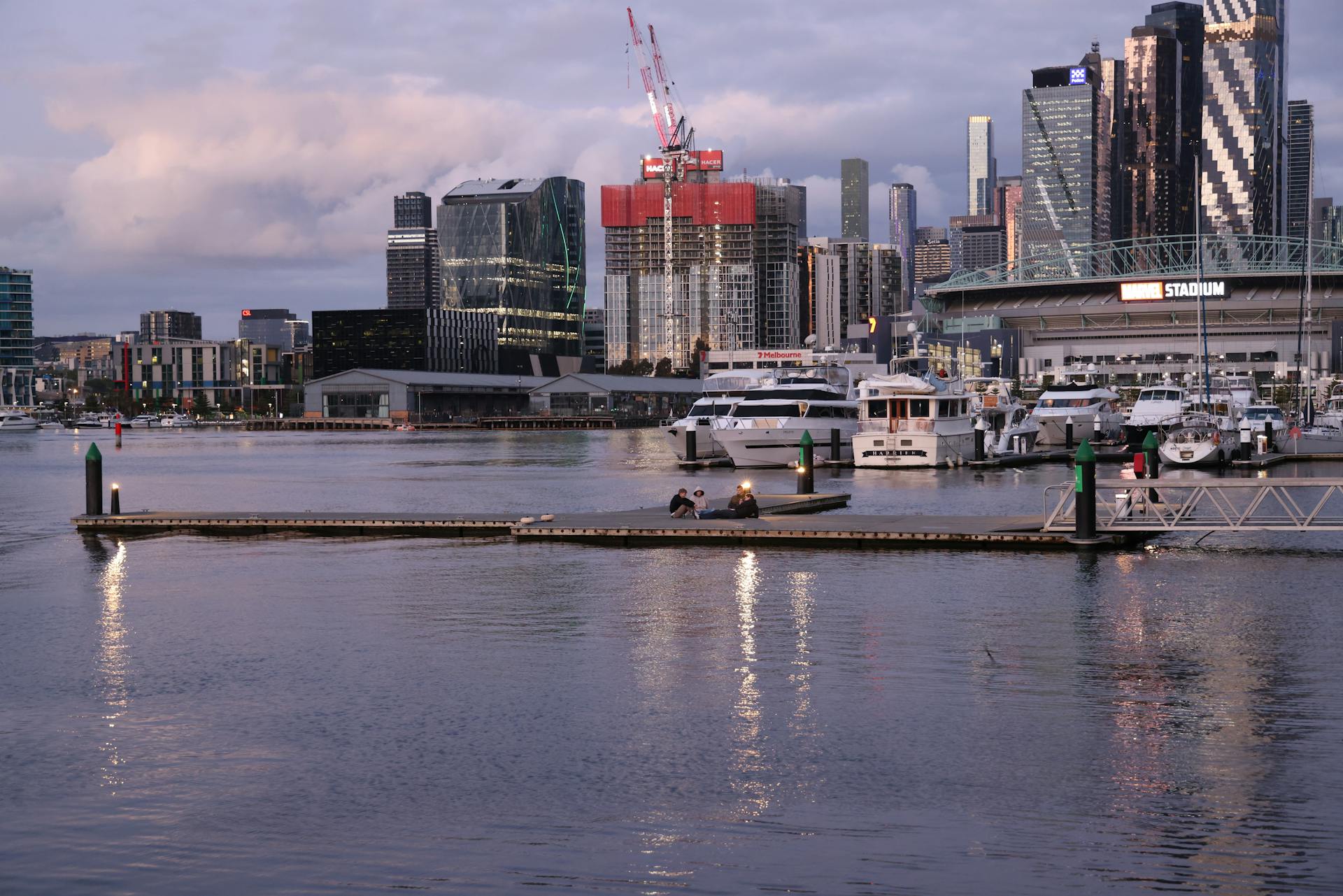 Stunning view of Melbourne Docklands skyline at sunset with yachts and modern buildings.