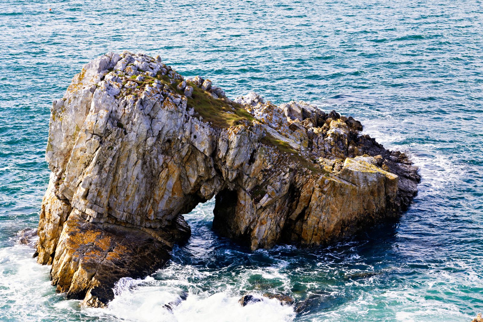 Large boulders piled along a rocky ocean shoreline to block wave erosion