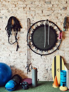 A diverse range of gym equipment arranged neatly against a rustic brick wall in a fitness studio.