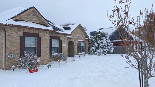 Festive winter scene of a house adorned with holiday decorations and snow.