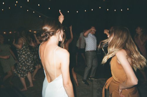 Free Young adults dancing joyfully at a night party under string lights. Stock Photo