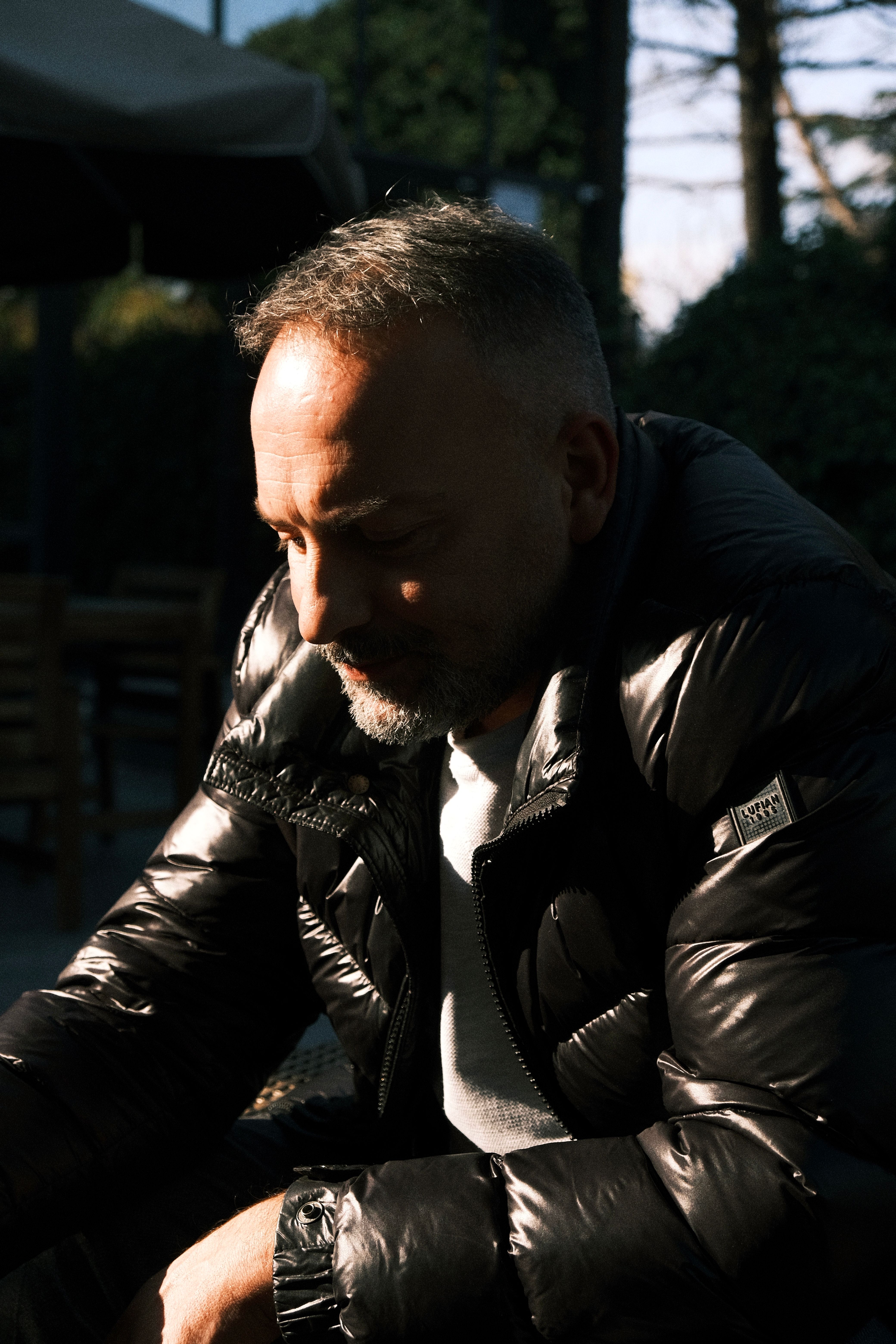 Thoughtful mature man in winter jacket sitting outdoors in Istanbul