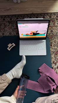 A home exercise setup with online fitness class on a laptop. Perfect for remote fitness enthusiasts.