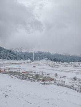 Stunning winter panorama featuring snow-covered mountains and a serene valley.