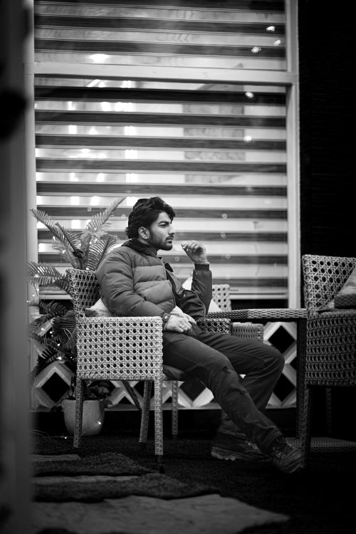 Free A contemplative man dressed warmly sits alone in an outdoor setting, deep in thought. Stock Photo
