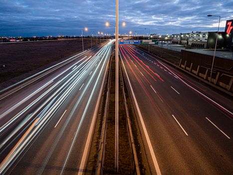 A dynamic view of light trails from vehicles on a freeway in Wrocław, Poland at night.