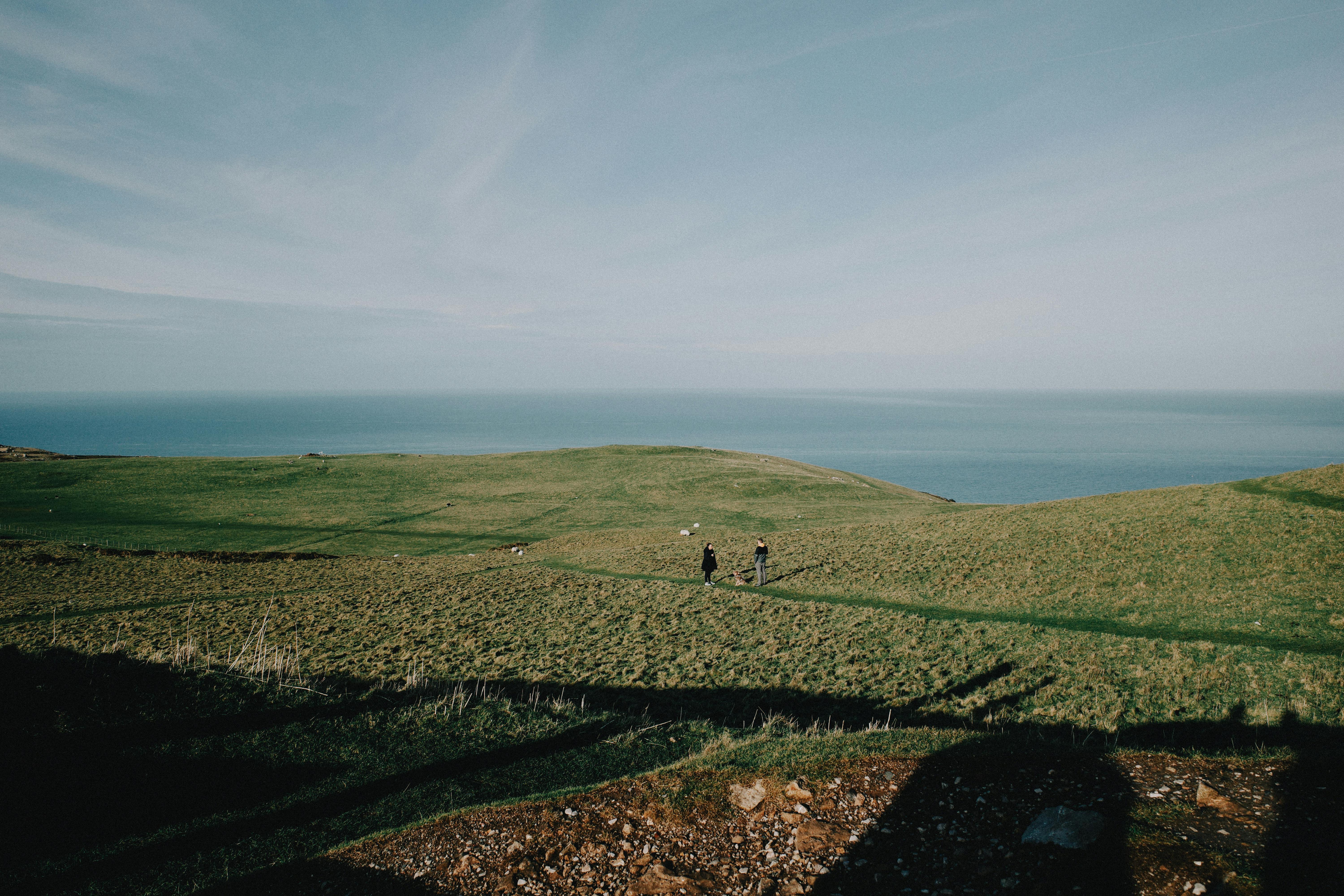 Breathtaking view of Llandudno's coastal landscape with grassy hills and sea horizon under a clear blue sky.