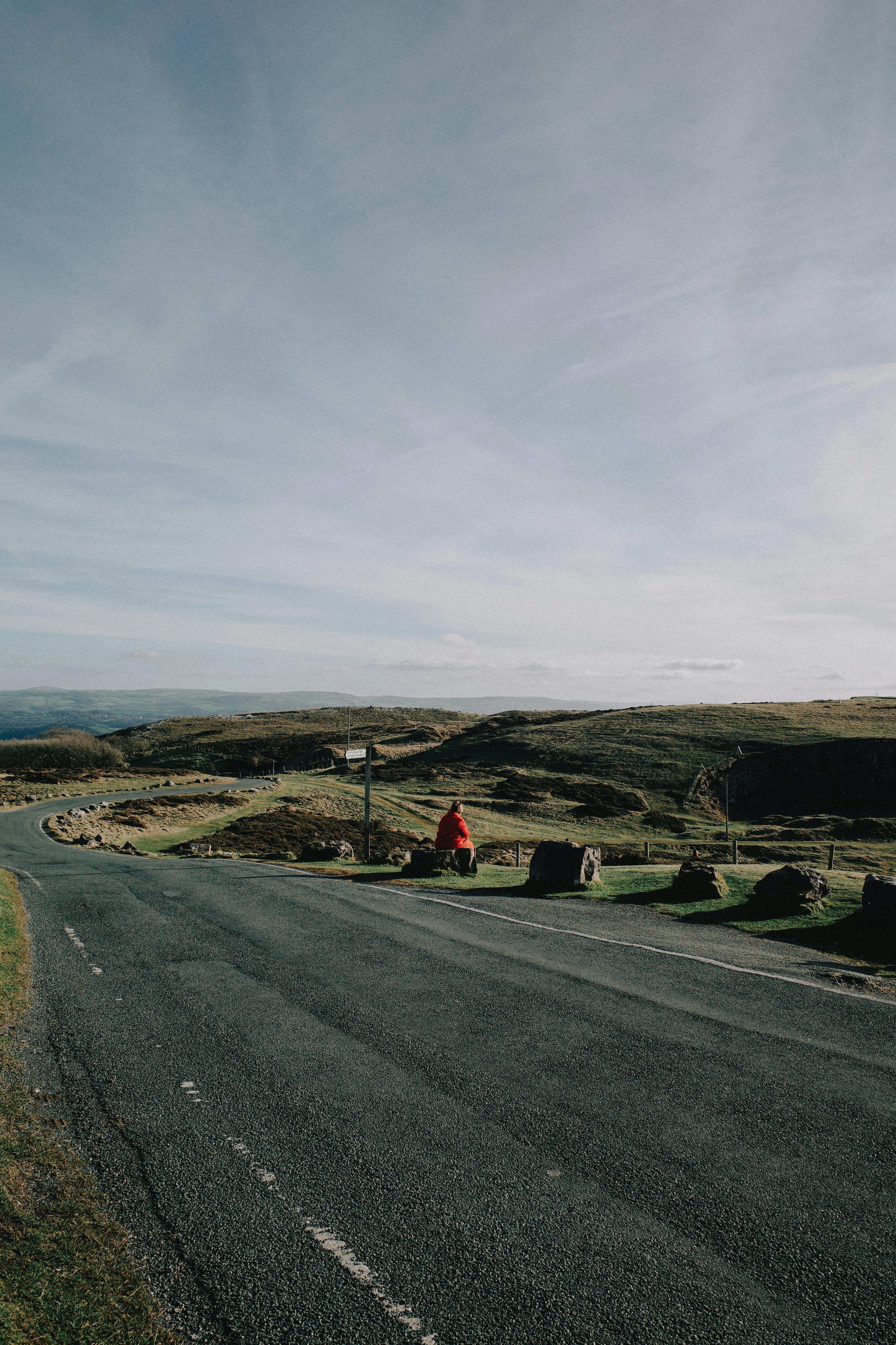 Tranquil view of Welsh countryside along a winding road under a clear sky.