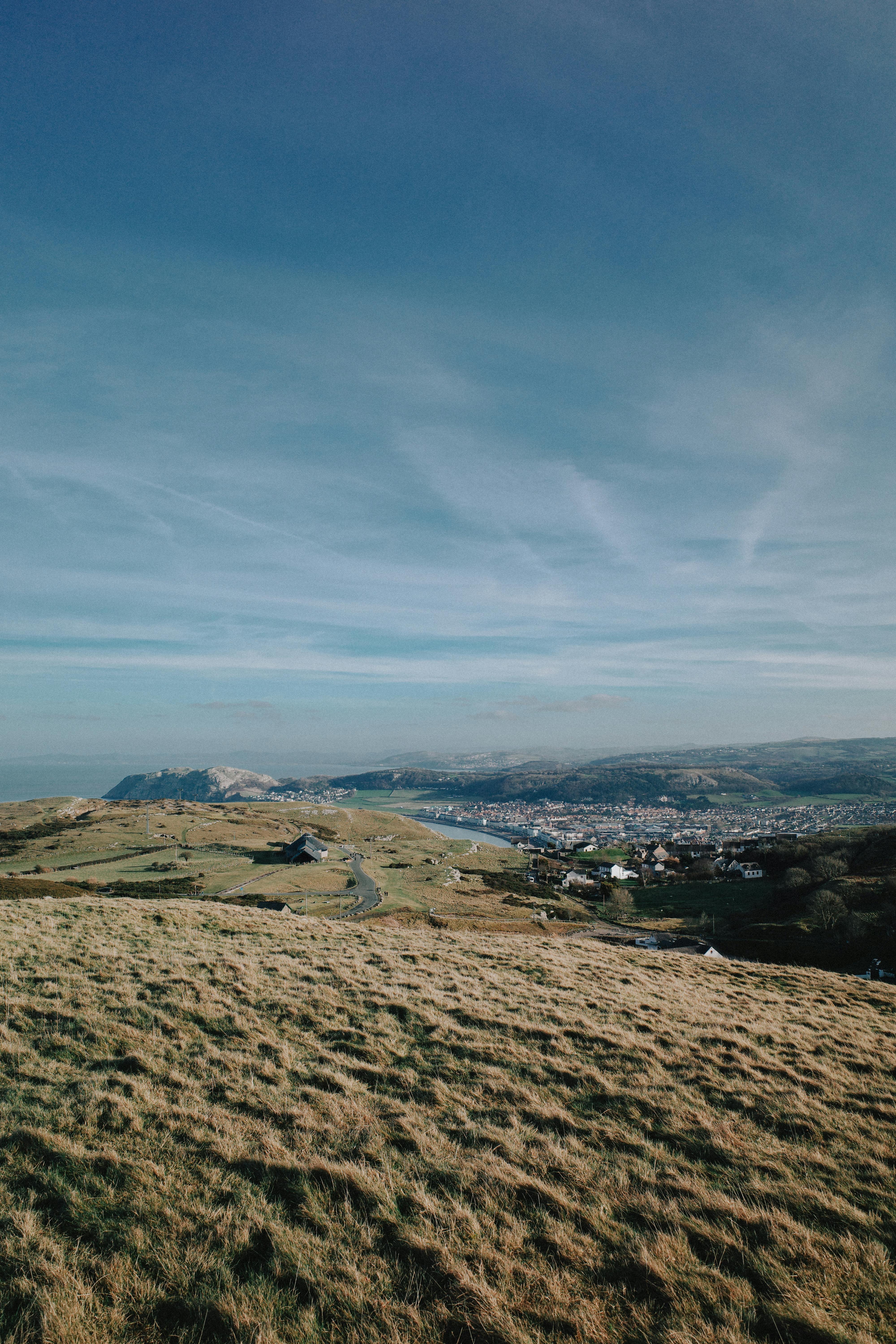 A breathtaking landscape of the rural Welsh countryside with rolling hills under a clear sky.
