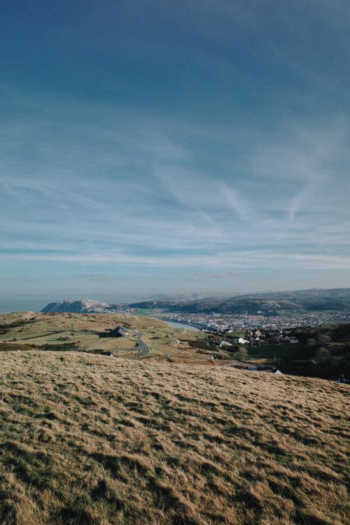 Free A breathtaking landscape of the rural Welsh countryside with rolling hills under a clear sky. Stock Photo