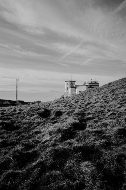 Free Black and white photo of a modern building atop a grassy hill in Wales. Stock Photo