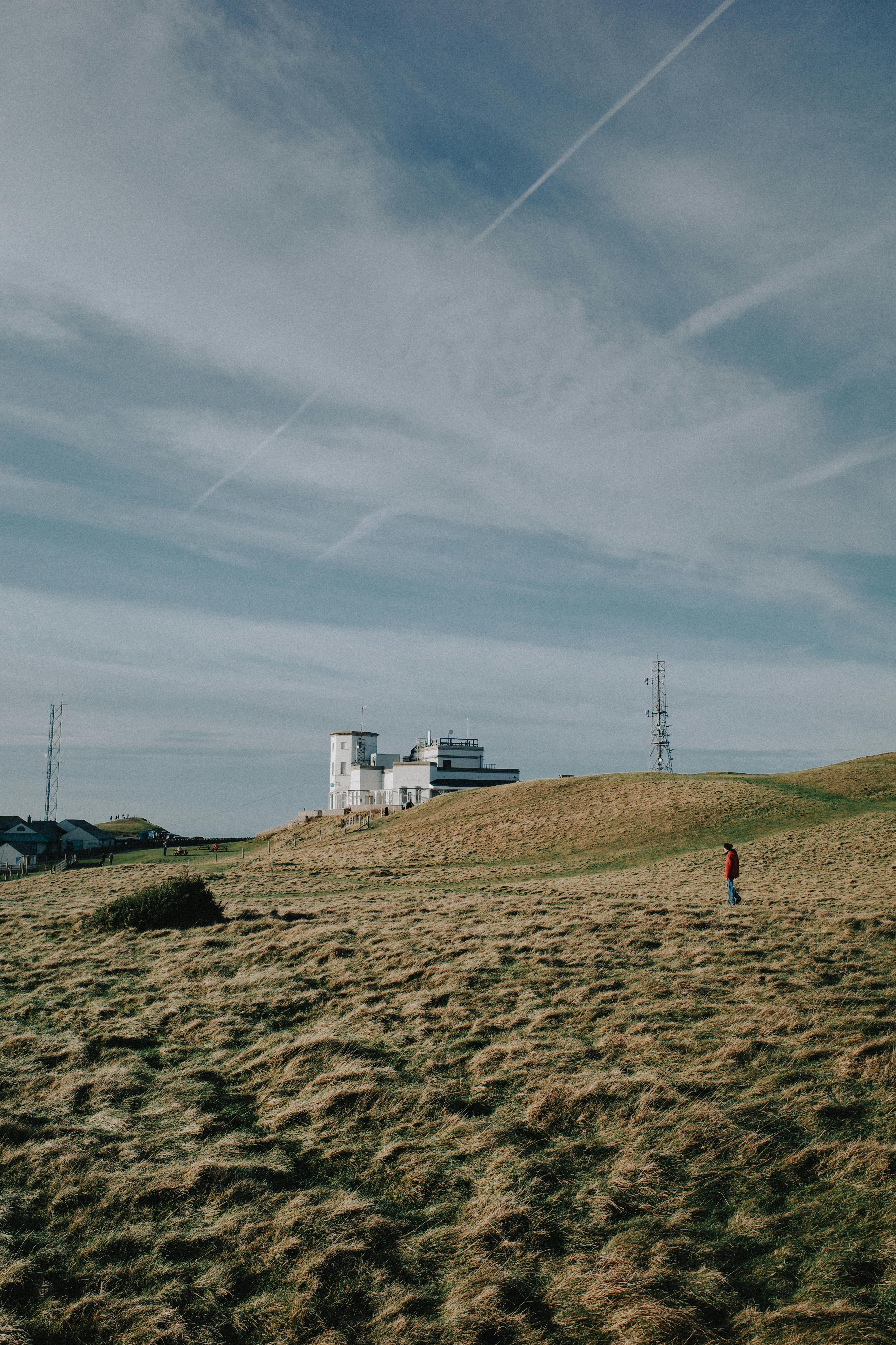 Solitary figure walking on grassy hillside with a scenic view in Wales.
