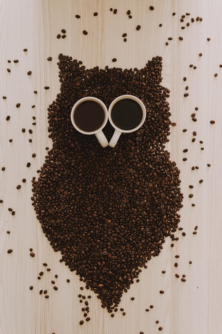 Two White Ceramic Mugs Surrounded With Coffee Beans