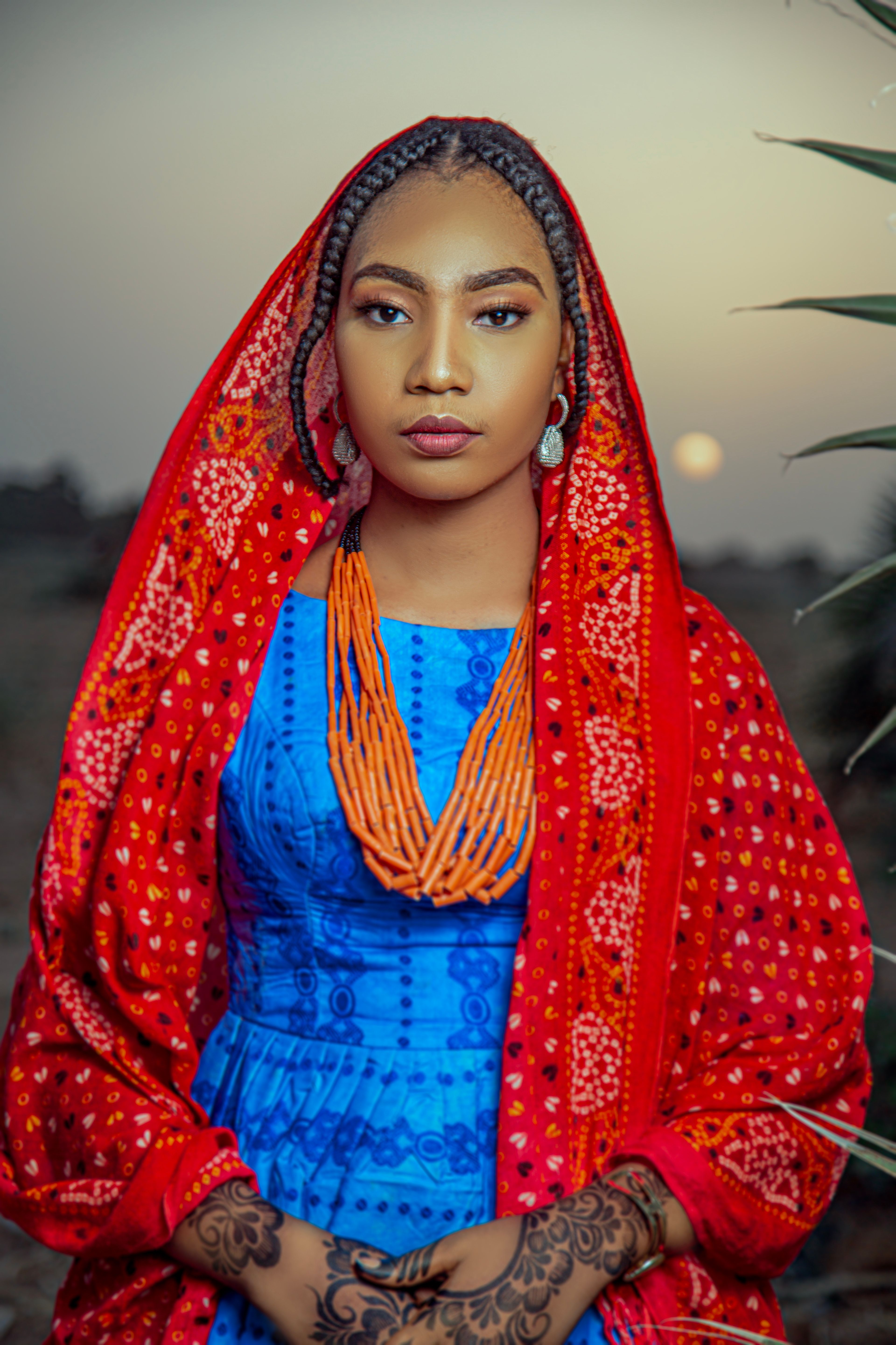Beautiful portrait of a woman in vibrant Nigerian traditional clothing at dusk.