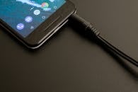 黑暗背景上，一个正在充电的智能手机特写镜头展示着现代界面