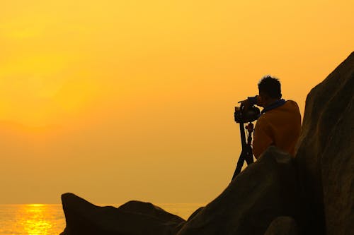 Mann Hält Dslr Kamera Während Der Goldenen Stunde