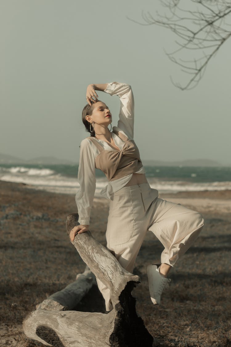 Woman Standing Near Driftwood