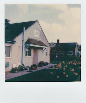A cozy suburban house with a vibrant flower garden in a Polaroid style.